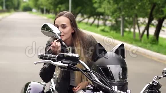 女孩坐在摩托车上画嘴唇视频的预览图
