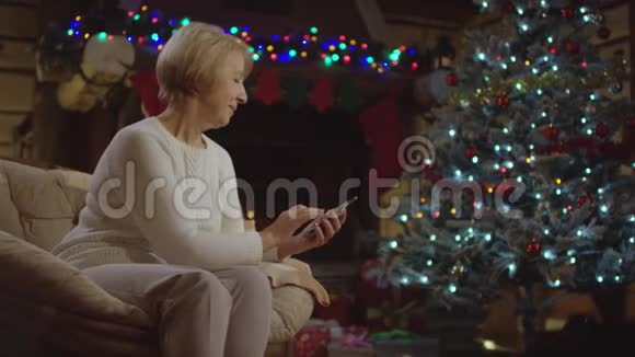 圣诞树上有智能手机的老太太视频的预览图
