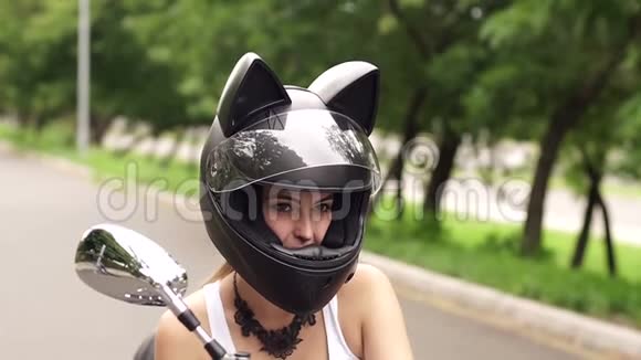 女孩坐在摩托车上戴着猫耳朵的头盔视频的预览图