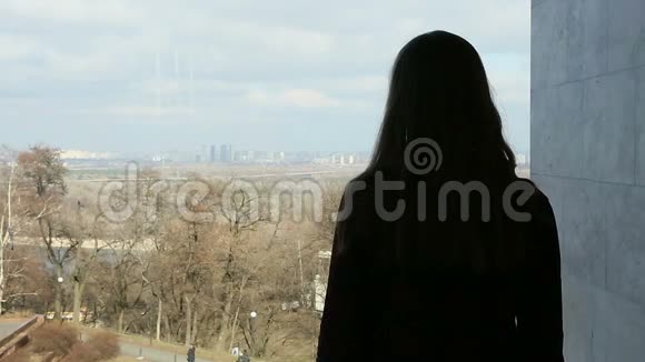 沮丧的年轻女子透过大窗户望着美丽的公园视频的预览图