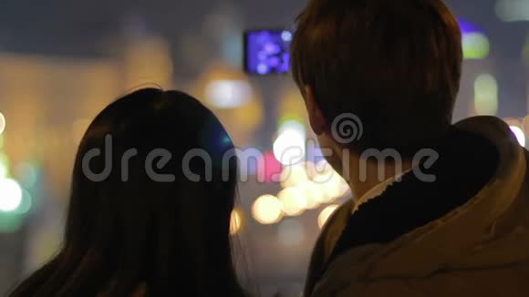 男人和女人在智能手机上拍照在城市放松的夜晚视频的预览图