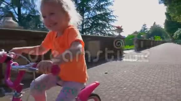 阳光明媚的一天小女孩骑自行车视频的预览图