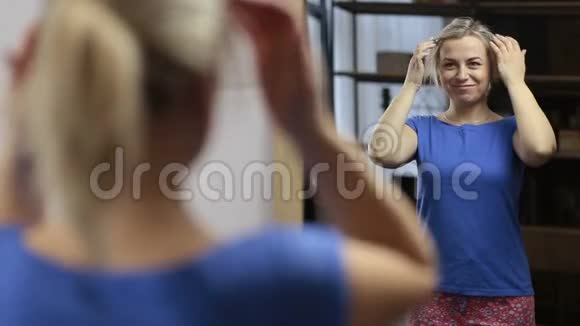 快乐的女人对镜子里的倒影感到满意视频的预览图