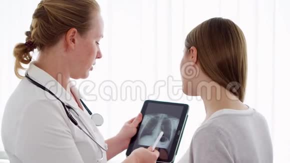 女性医生在临床上向女性患者显示X光女性职业医生视频的预览图