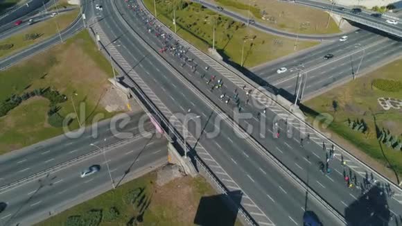 空中无人机镜头在公路路口跟着马拉松赛跑小组视频的预览图