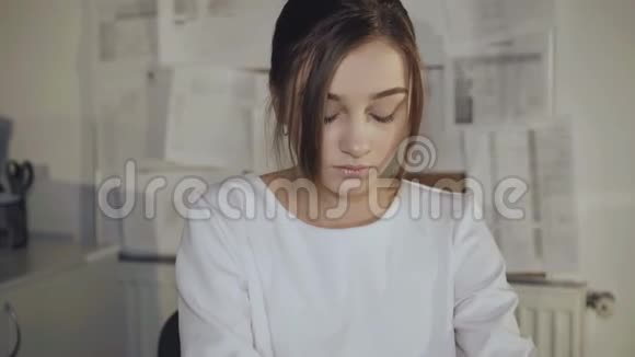 平静的年轻女孩在工作场所微笑使用平板电脑4K视频的预览图
