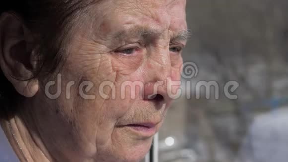 老年妇女因颤抖的眼睑而痛苦的面部特写视频的预览图