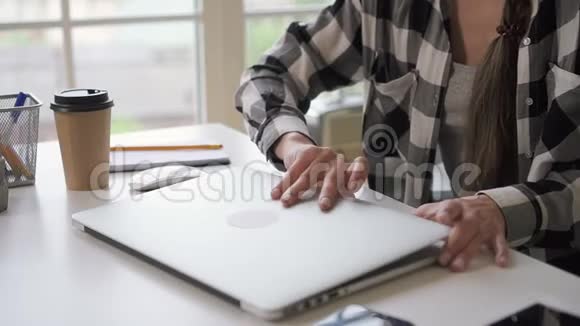 年轻的企业主女士打开笔记本电脑坐在明亮的房间里的家庭工作场所视频的预览图