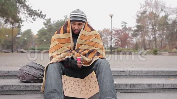 善良的年轻女子把钱给穷无家可归的男人在街上乞讨帮助视频的预览图