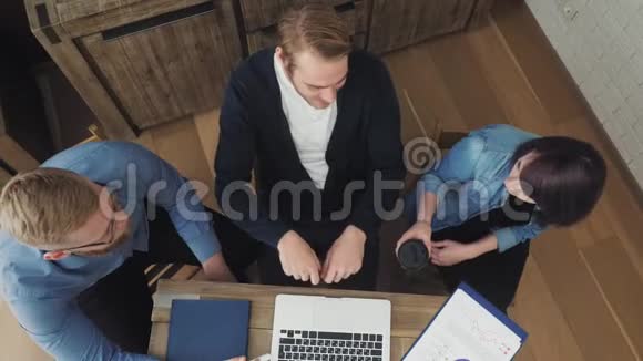 团队在创意办公室坐在办公桌前用笔记本电脑工作视频的预览图