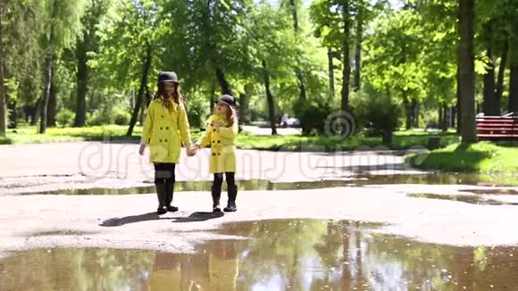 年轻女孩在公园里的水坑里奔跑视频的预览图