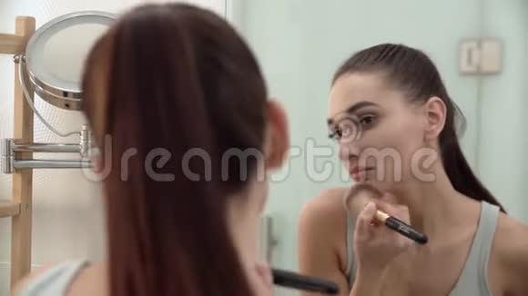 化妆女人用粉末照镜子视频的预览图