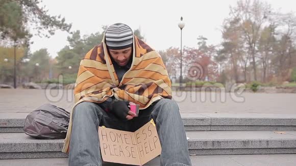 穷人在城市公园要求慈善可怜的无家可归者需要帮助视频的预览图