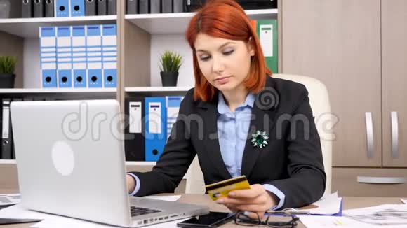 女商人前面有一台笔记本电脑介绍从卡片到网上购物的数据视频的预览图