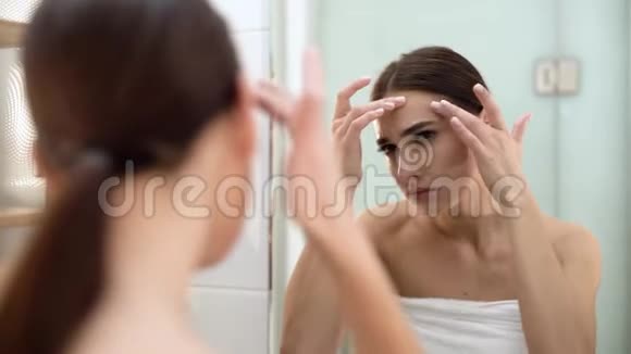问题皮肤女人脸上的红斑和镜子里的红斑视频的预览图