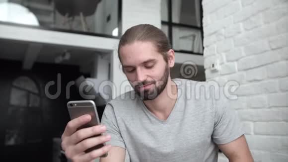 带手机的男人在家喝咖啡厨房视频的预览图