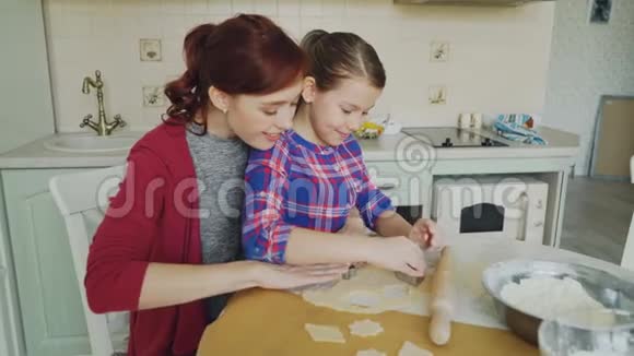 快乐的母亲和小女儿一起做饼干用面包店的形式在现代的时候做面团视频的预览图