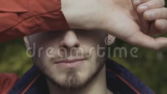 男人用耀眼的阳光遮住他的脸视频的预览图