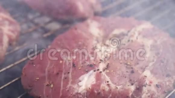 烧烤架上烹制多汁的生肉牛排视频的预览图