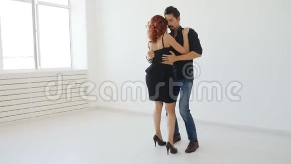 爱和关系的概念一对漂亮的年轻夫妇在白色的房间里跳舞视频的预览图