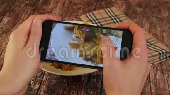 女人用智能手机拍照晚餐食物那个女人正在拍食物特写镜头视频的预览图