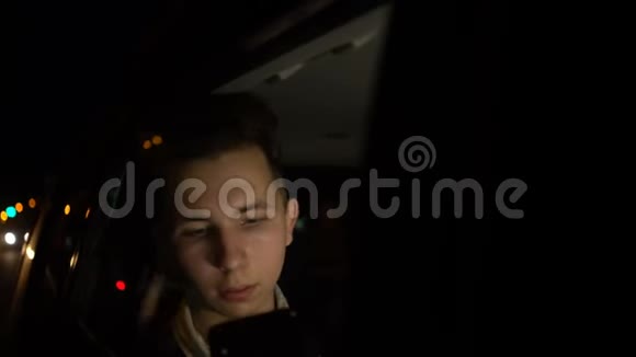 深夜在汽车后座用手机玩应用程序的青少年视频的预览图
