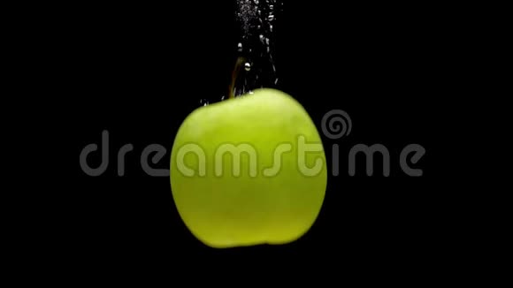 一个绿苹果掉在透明的水中黑底视频的预览图