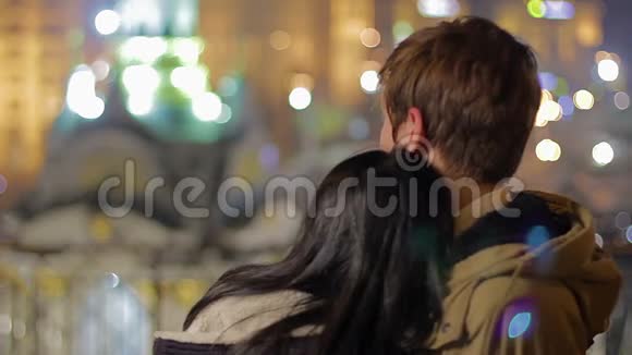 相爱的情侣拥抱在一起欣赏美丽的夜景视频的预览图