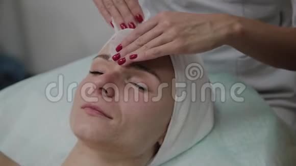 一位美丽的女性美容师在手术前用棉垫擦脸视频的预览图