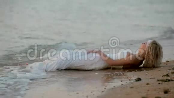 新娘躺在海滩上视频的预览图