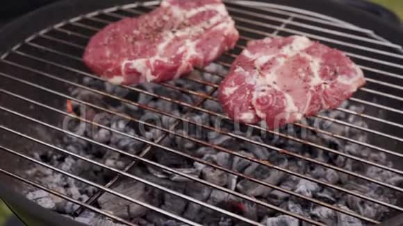 烧烤架上烹制多汁的生肉牛排视频的预览图