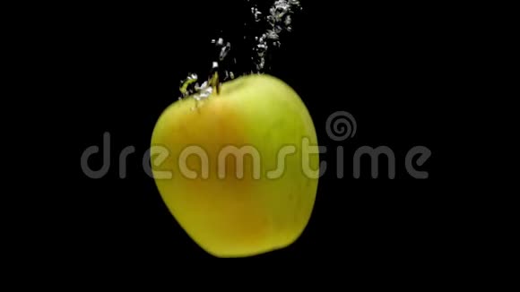 一个黄色的苹果落在透明的水中黑色的背景视频的预览图