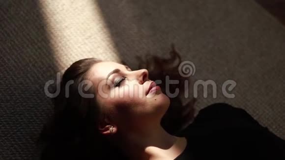 年轻的孕妇躺在窗户附近阳光照射在女人身上视频的预览图