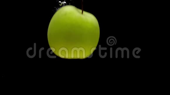 一个绿苹果掉在透明的水中黑底视频的预览图