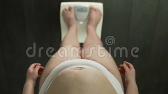 节食不成功体重超重的女人站在秤上对结果生气视频的预览图