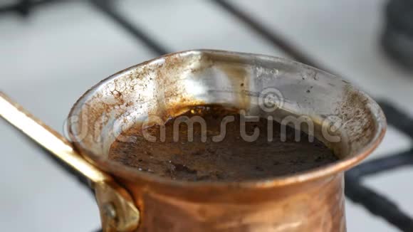 在靠近视野的白色煤气炉上用铜桶煮着脱缰的黑咖啡视频的预览图