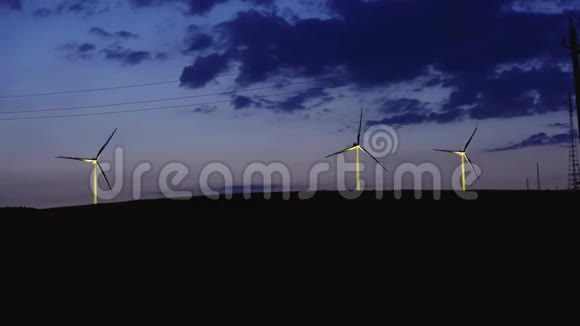 几个风车在夜间黄昏地平线风力在田野视频的预览图