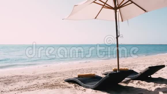 沙滩床上有带伞的沙滩和蓝天视频的预览图