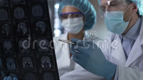 神经外科医生显示人体MRI扫描并向内科实习生解释视频的预览图
