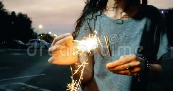 女孩在夜晚的街道上点燃孟加拉灯视频的预览图