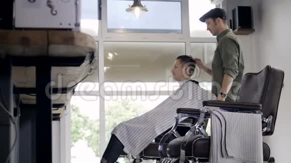 一位发型师轻轻梳理了男性客户的短湿头发视频的预览图