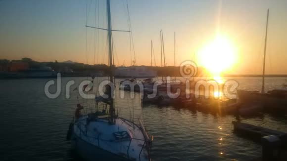 游艇和船只停靠在码头附近美丽的日落和自然黄金时刻视频的预览图