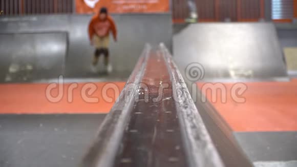 一个穿着橙色运动衫的人在溜冰场里用溜冰鞋溜冰动作很慢Nifft视频的预览图