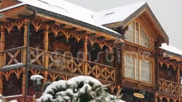 在大雪纷飞期间可以近距离观看带有夹层的山村小屋带有俄罗斯风格雕刻的木制立面视频的预览图