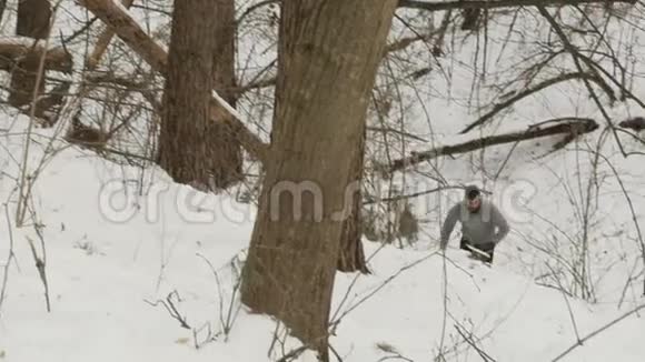 肌肉运动员在森林里的雪山上移动视频的预览图