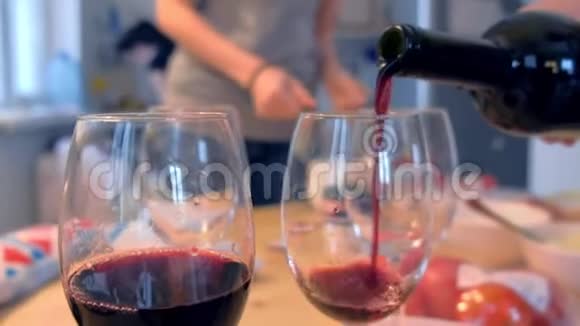在家里的厨房里红酒被倒进酒杯里视频的预览图