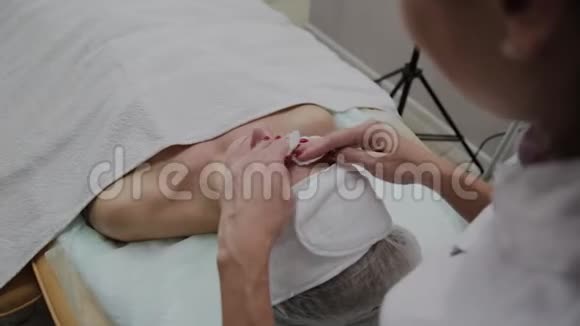 一位美丽的女性美容师在手术前用棉垫擦脸视频的预览图