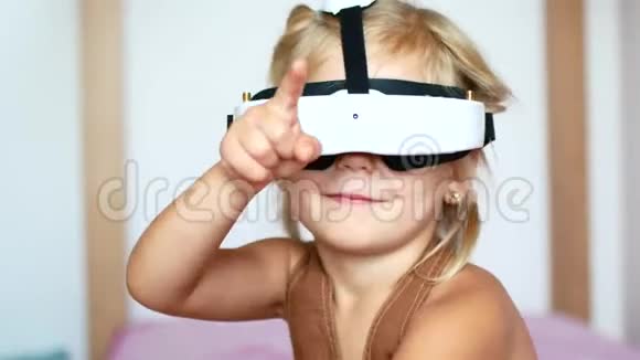 小女孩戴着虚拟现实眼镜玩电子游戏快乐的微笑看着VR眼镜和手视频的预览图