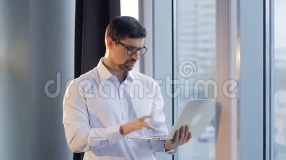 一个忙碌的企业家用一只手的手指在笔记本电脑上打字视频的预览图