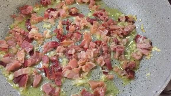 平底锅配炒菜熏肉洋葱和特级初榨橄榄油视频的预览图